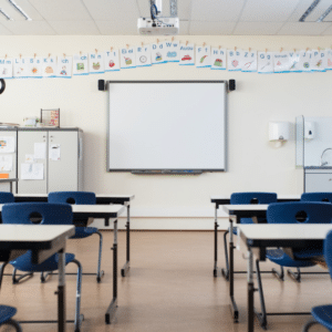 A classroom with desk and chairs and a whiteboard in special education room
