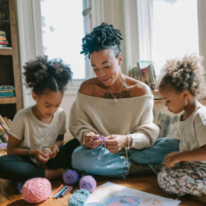 Black woman with locs crocheting with her daughters in homeschooling