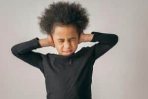 A Child covering his ears due to ears, a sign of meltdowns in ADHD.